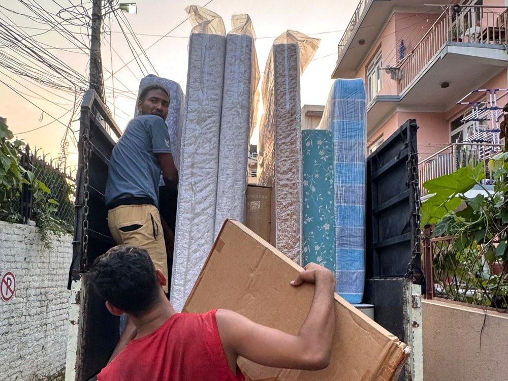 Team loading mattresses and boxes onto truck